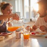 Junges, gut gelauntes Paar beim gesunden Frühstück